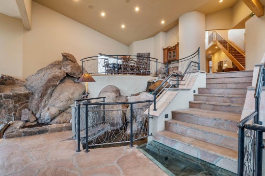 Внутри дома на склоне горы видны валуны, вокруг которых он построен.