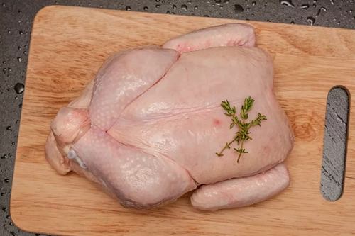 Куриная тушка на разделочной доске Куриная тушка на разделочной доске