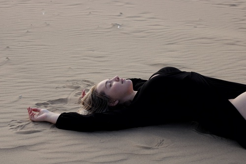 Девушка лежит на песке